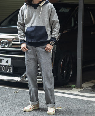 Striped carpenter pants with button fly and side pockets, cuffed at the hem.