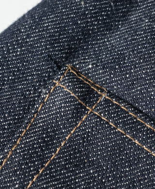 Dark denim jeans belt loop and tan stitched yoke seam detail