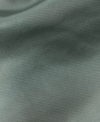 Olive MA-1 flight jacket fabric close-up with textured weave and subtle sheen
