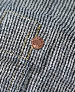 Indigo denim jacket copper logo button on yellow-stitched panel