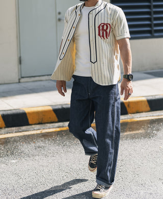 Indigo denim painter pants worn with straight-leg fit and belt loops