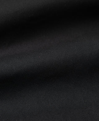 Close-up of black waxed jacket fabric with subtle textured weave