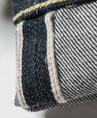 Indigo selvedge denim jeans cuff with contrast off-white stitching and edge detail