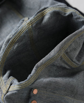 Indigo denim jacket collar/hem area with copper buttons and yellow welt stitching