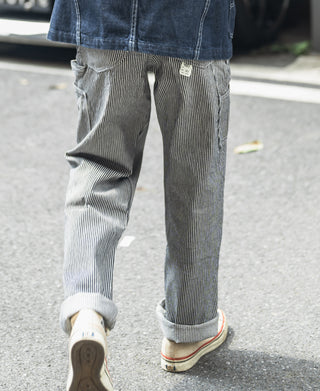Striped carpenter pants with back patch pockets and relaxed taper at the ankle.