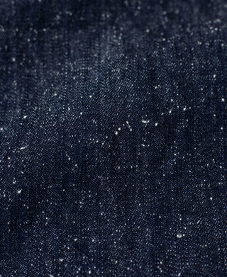 Indigo denim fabric with speckled slub texture and visible woven grain