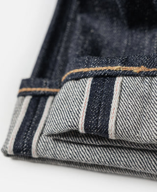 Indigo denim jeans cuff showing white selvedge band with contrast stitching