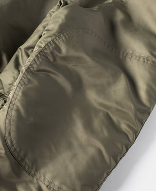 Olive parka side pocket opening with curved welt