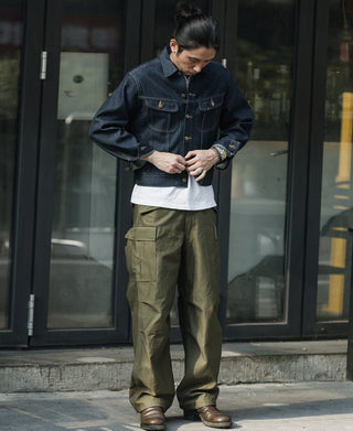 Indigo denim jacket worn open with button front and flap pockets
