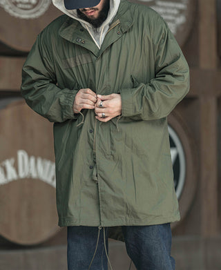 Olive green M-65 style parka with hood, front zip, and chest pocket