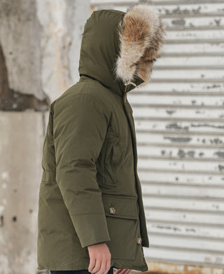 Olive down parka side view with faux-fur hood trim and snap pocket flap