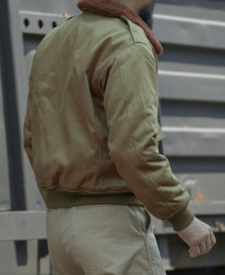 Khaki green flight jacket side view with ribbed waistband