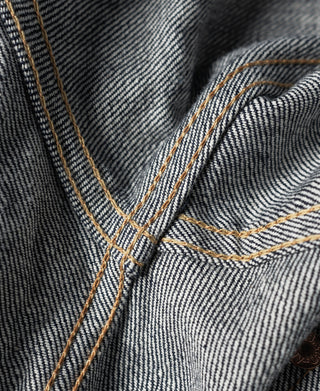 Indigo denim jacket interior panel with tan triple-row topstitching