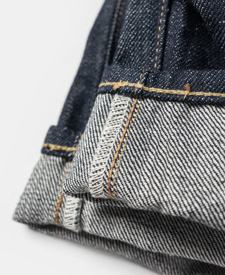 Dark denim jeans hem seam with tan stitch line and white thread reinforcement