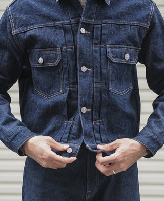 Indigo denim jacket front with button placket, chest pockets, orange contrast topstitch