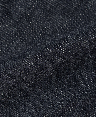Indigo denim fabric close-up with speckled texture and visible weave