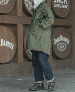 Olive green M-65 style parka with hood, side pockets, and adjustable cuffs
