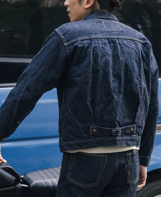 Indigo denim jacket back view with adjustable strap at hem
