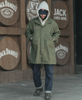 Olive green M-65 style parka with hooded neckline and front button closure