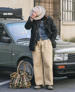 Black waxed chore jacket with fur-trimmed hood, button closure, and front pockets