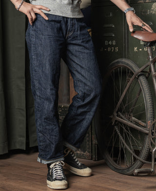 Dark blue denim jeans, full-length side view with belt loops and stitched seams