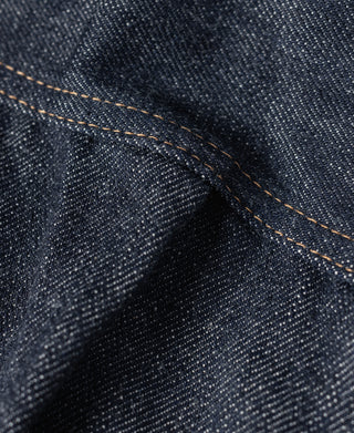 Indigo denim jacket fabric closeup with tan contrast seam line