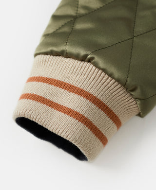 Ribbed knit cuff on olive jacket with tan, orange, and white striped band