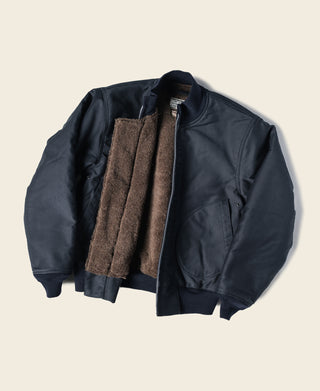 Navy deck jacket with zip front, ribbed cuffs, and tan fleece lining visible