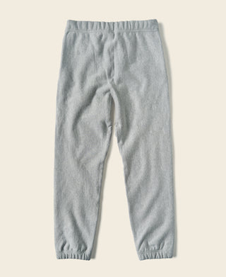 Light gray jogger sweatpants laid flat with elastic waistband and tapered cuffs