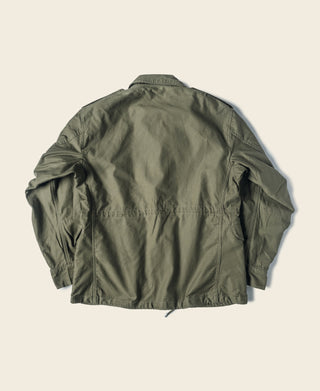 Olive M-1951 field jacket back view with button closures and utility seams