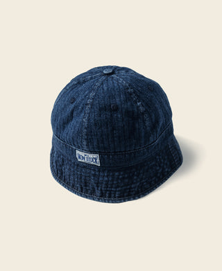Indigo herringbone denim bucket hat with front badge and rounded crown