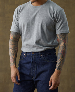 Gray cotton tubular T-shirt with crew neck, male model wearing dark blue jeans.
