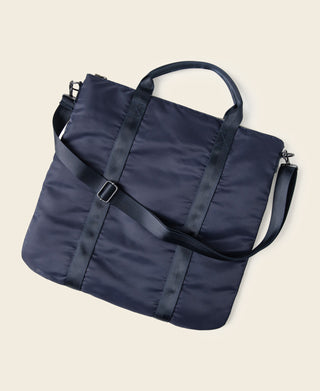 Navy fabric duffel-style helmet bag with webbed shoulder strap and side hardware