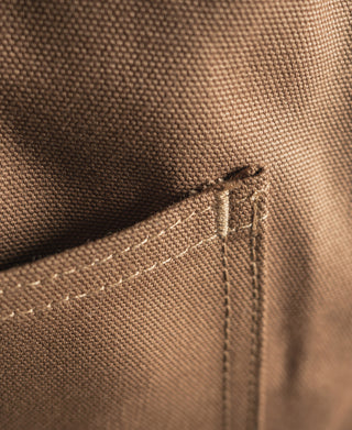 Close-up of khaki canvas hunting vest seam and stitched edge detail
