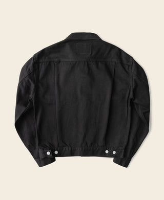 Black denim jacket back view with buttoned lower placket and seams