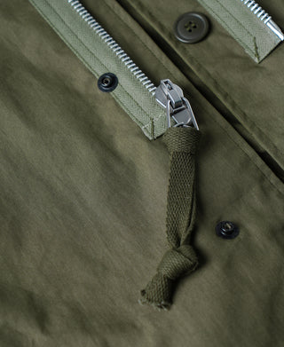 Olive M-65 parka front tie closure with metal clasp and snap buttons.