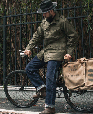 Olive field jacket worn by man, flap chest pockets and utility seam details