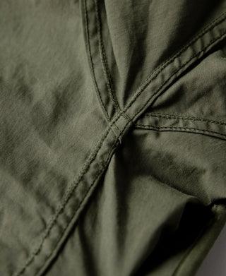 Olive M-65 parka neckline seam with flap and stitched collar detail.