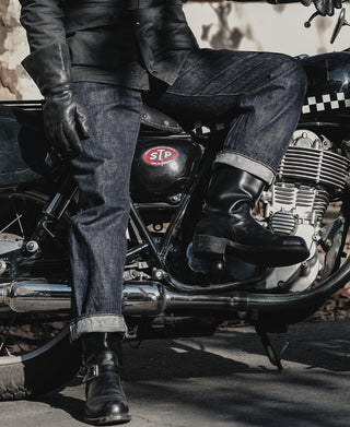Indigo denim jeans with folded cuffs and classic seam detailing along the legs