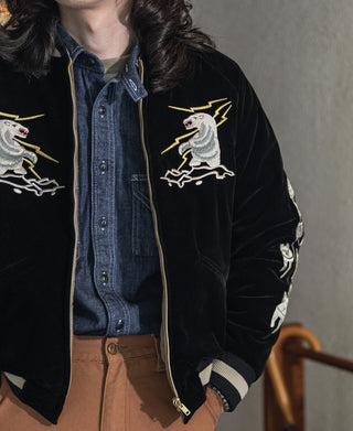 Black reversible souvenir jacket worn, zip front with Alaska eagle patch and striped ribbed cuffs.