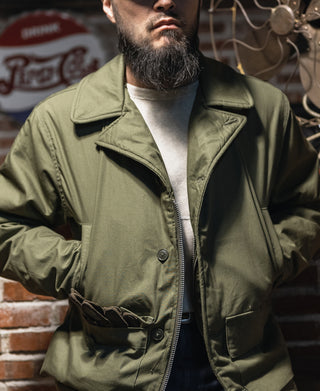Olive flight jacket with stand collar and front zipper, worn on model