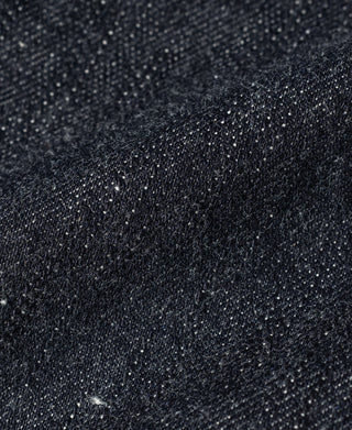 Indigo selvedge denim fabric with visible twill texture and fine speckle