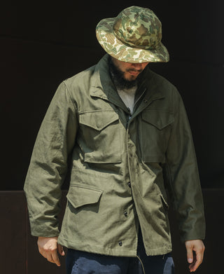 Olive field jacket with hood and button front, two chest flap pockets.