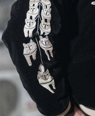 Black reversible souvenir jacket sleeve with stacked animal face embroidery, ribbed cuff.