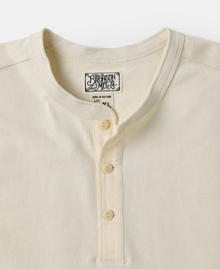 Henley neckline and three-button placket on light cream long-sleeve shirt