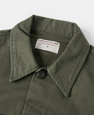 Olive fatigue utility shirt collar with button placket and fabric label at neck