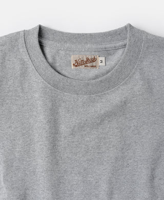 Gray cotton tubular T-shirt crew neckline with woven brand label inside collar.