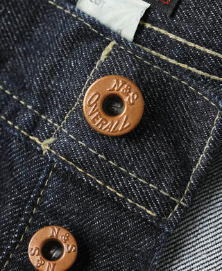 Indigo denim jeans close-up of copper snaps and yellow-stitched seam details