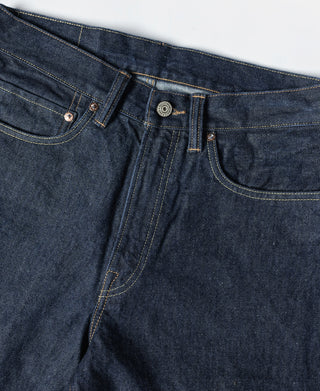 Indigo denim waistband detail with belt loops, coin pocket, and button closure
