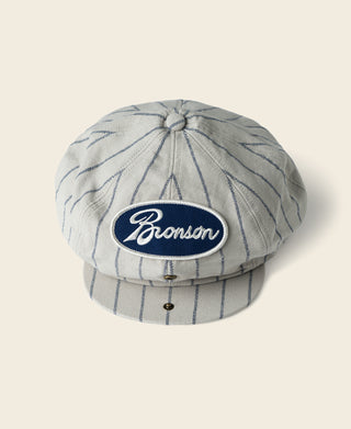 Gray railroad stripe newsboy cap with Bronson logo oval patch on crown